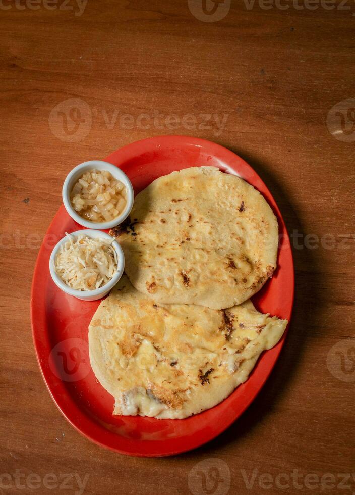 de cerca de nicaragüense pupusas servido en de madera mesa. delicioso tradicional salvadoreño pupusas con Derretido queso en de madera mesa. tradicional pupusas servido en un de madera mesa foto