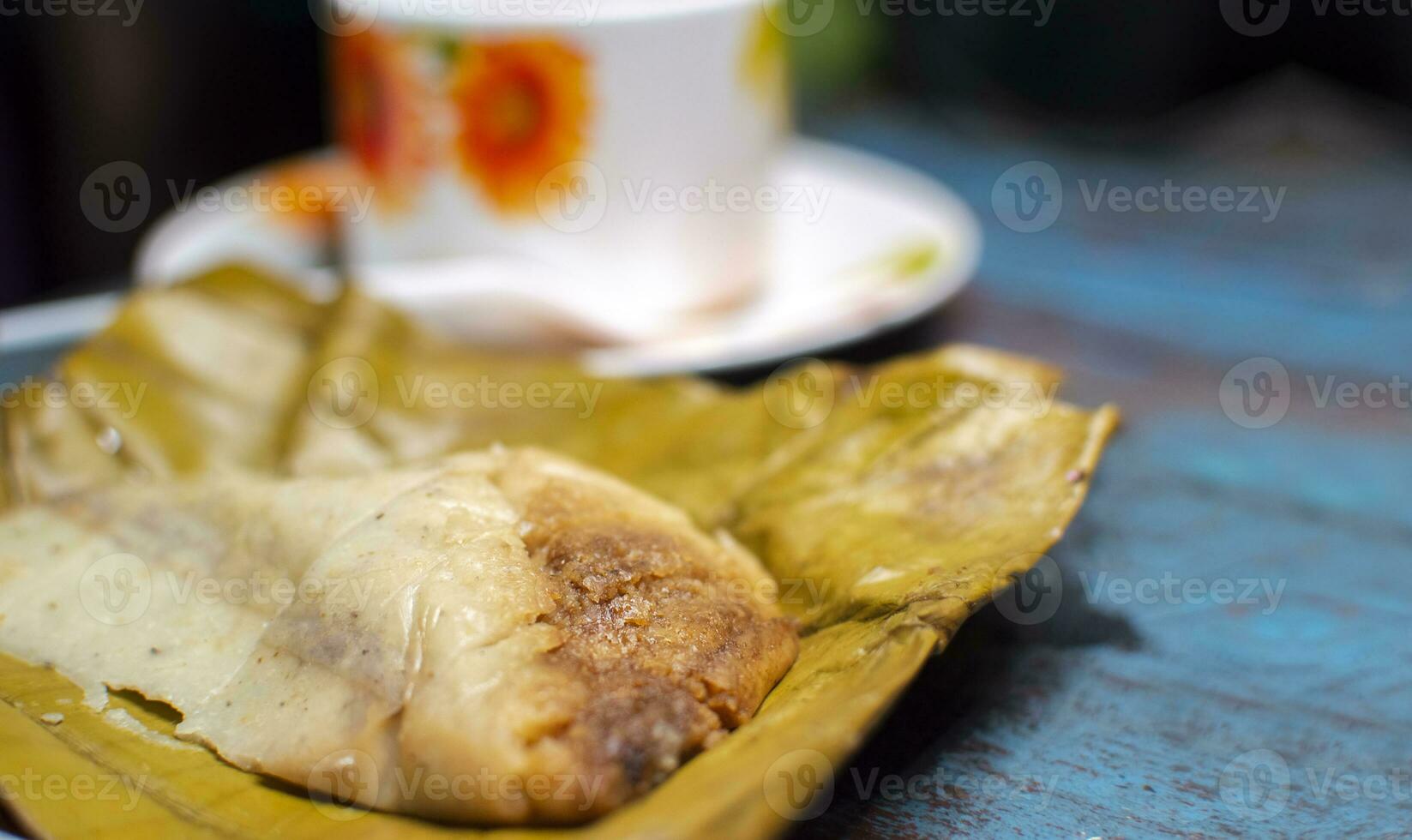 Stuffed tamale served on wooden table, stuffed tamale on banana leaf served on wooden table, typical nicaragua food photo