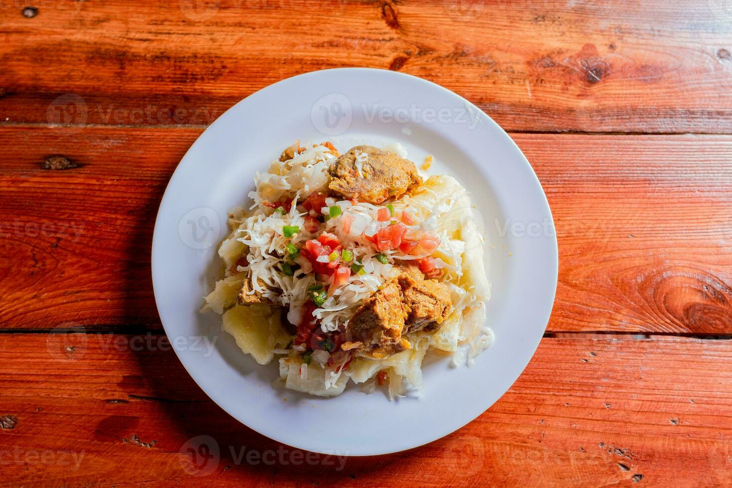 parte superior ver de tradicional chancho plato con yuca nicaragüense Cerdo con yuca servido en de madera mesa foto