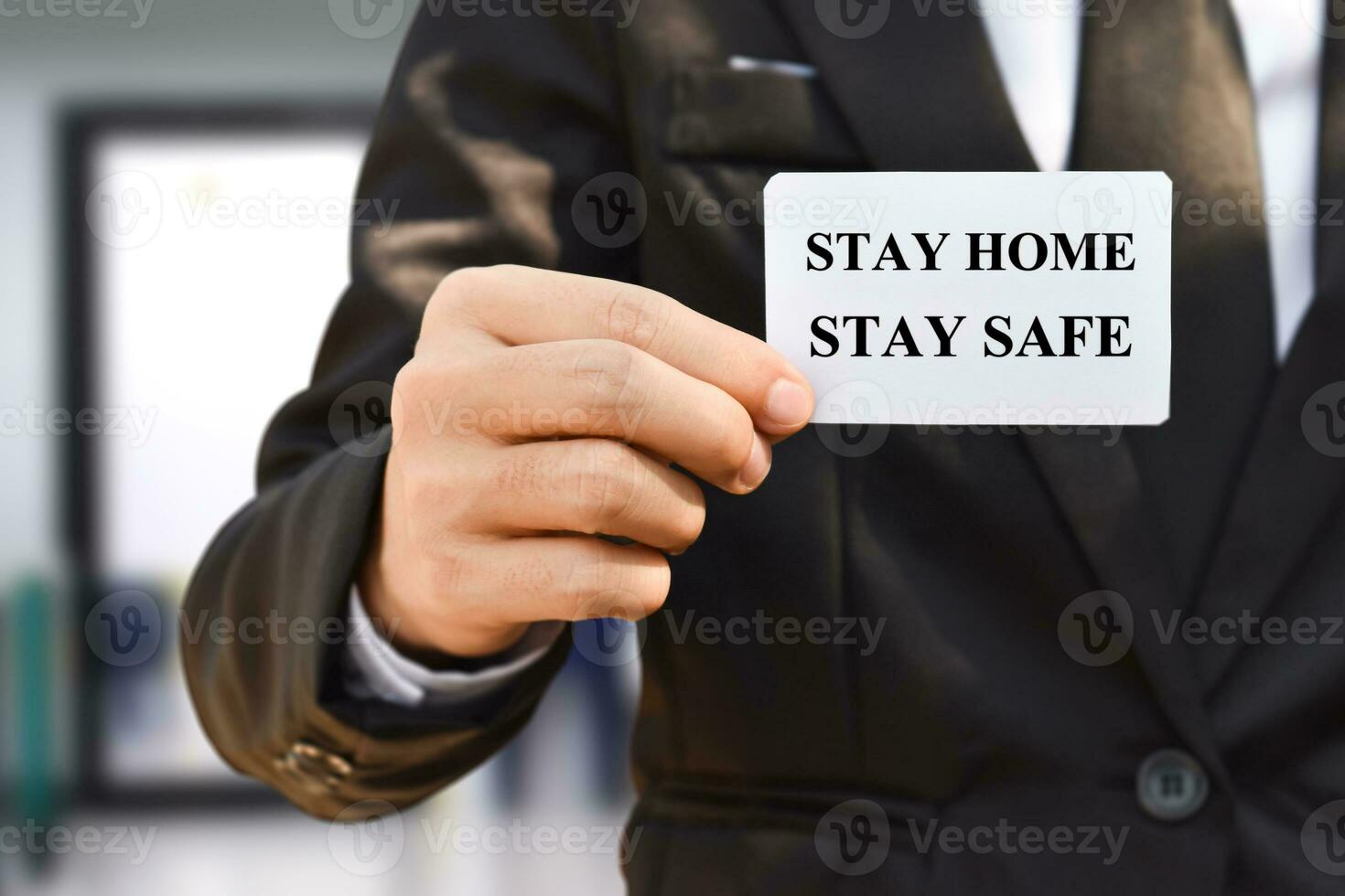 Close-up of businessman hand holding paper with stay at home. photo
