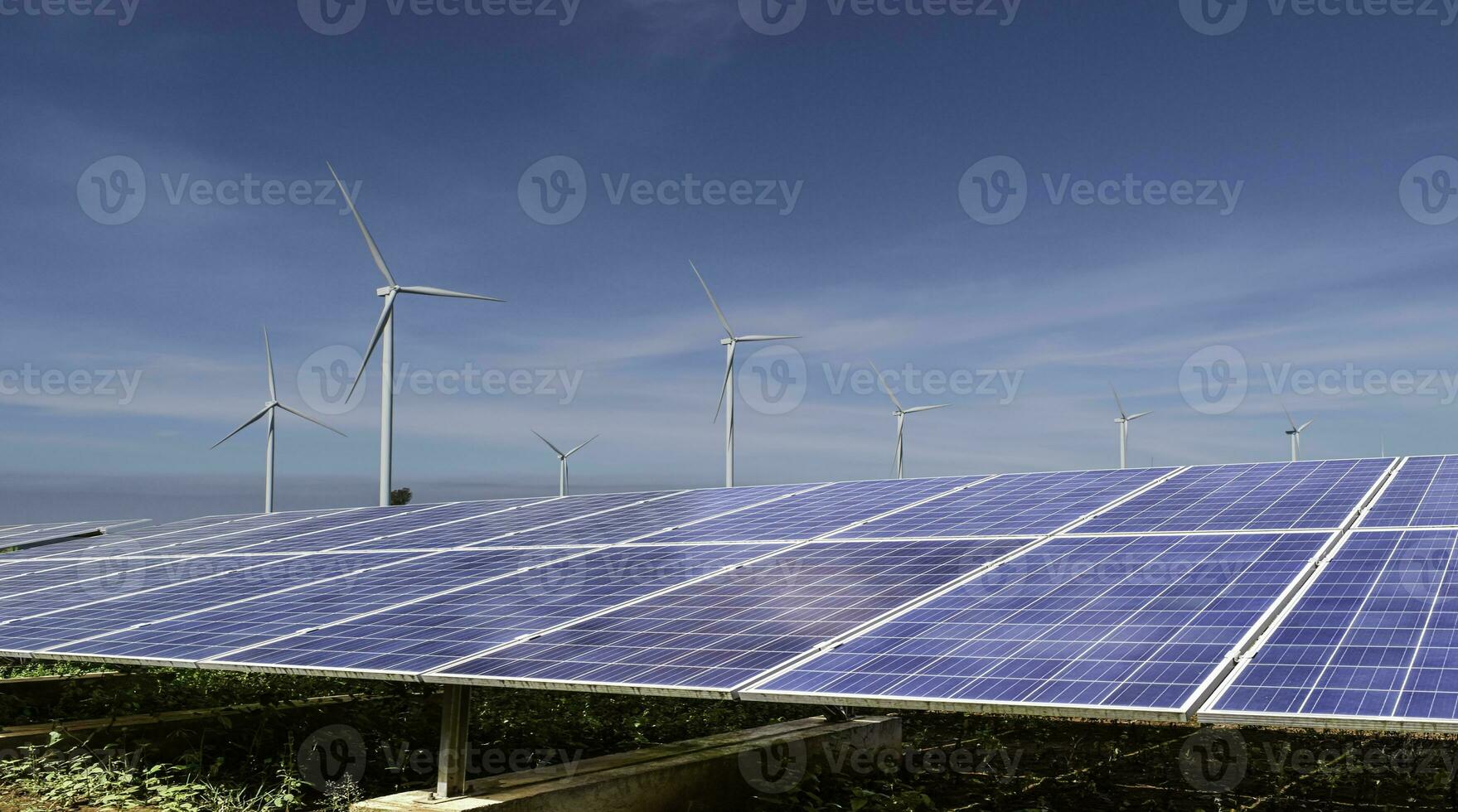 solar panels with wind turbines against blue sky background. Photovoltaic, alternative electricity source. sustainable resources concept. photo