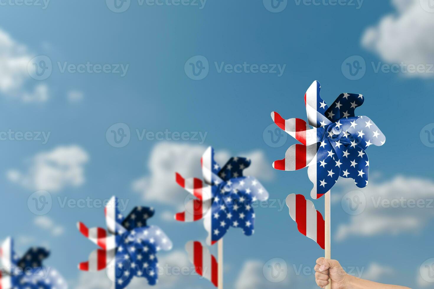 Hand holding wind turbine patriotic of USA over blue sky background. photo