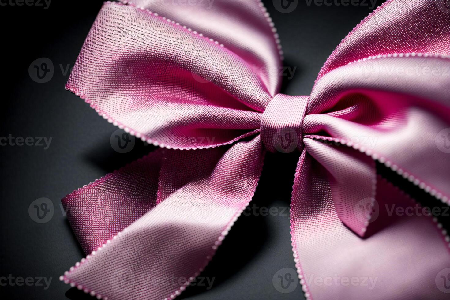A Close Up Of A Pink Bow On A Black Background. photo