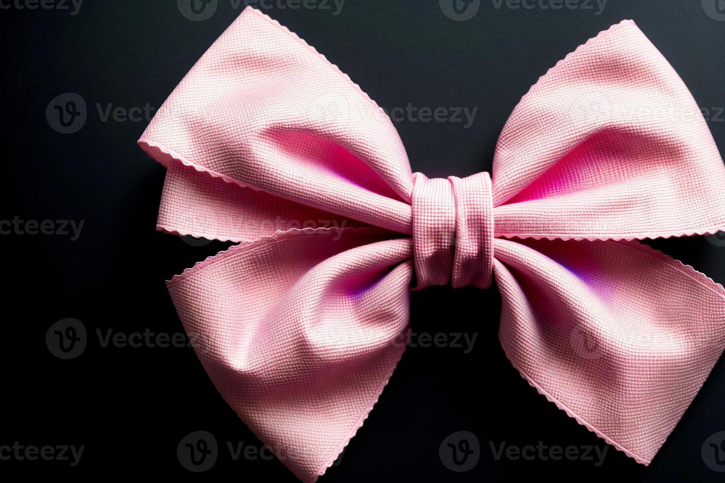 A Close Up Of A Pink Bow On A Black Background. photo