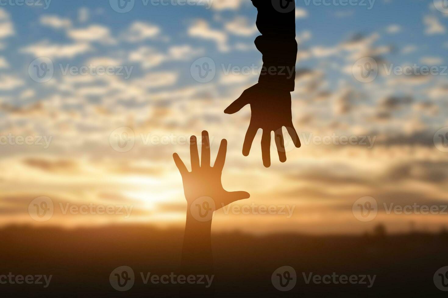 Silhouette of reaching, giving a helping hand, hope and support each other over sunset background. Help concept photo