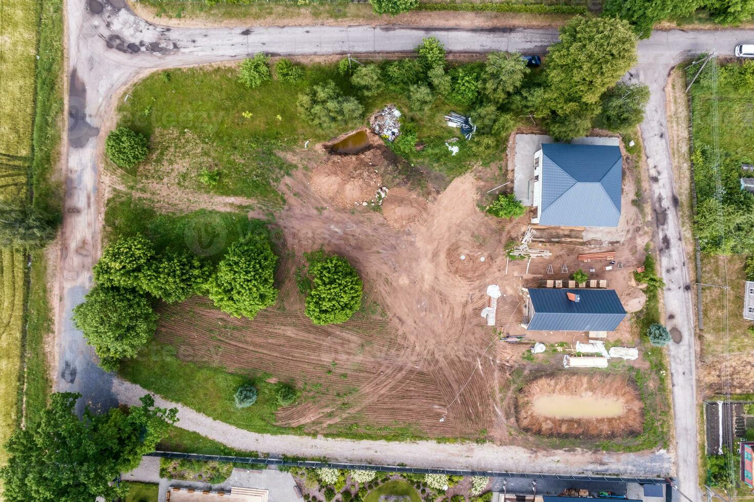 panoramic aerial view of eco village with wooden houses, gravel road, gardens and orchards photo