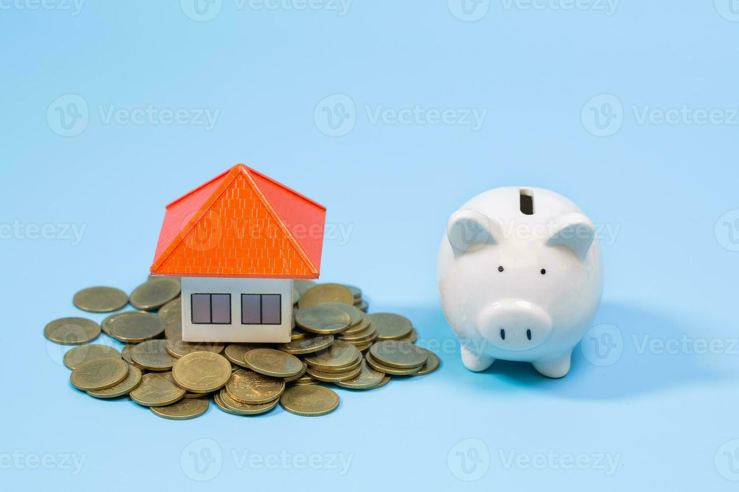 House on the coin and Piggy bank On a blue background,  planning savings money of coins to buy a home, property ladder, mortgage and real estate investment.  saving or investment for a house photo