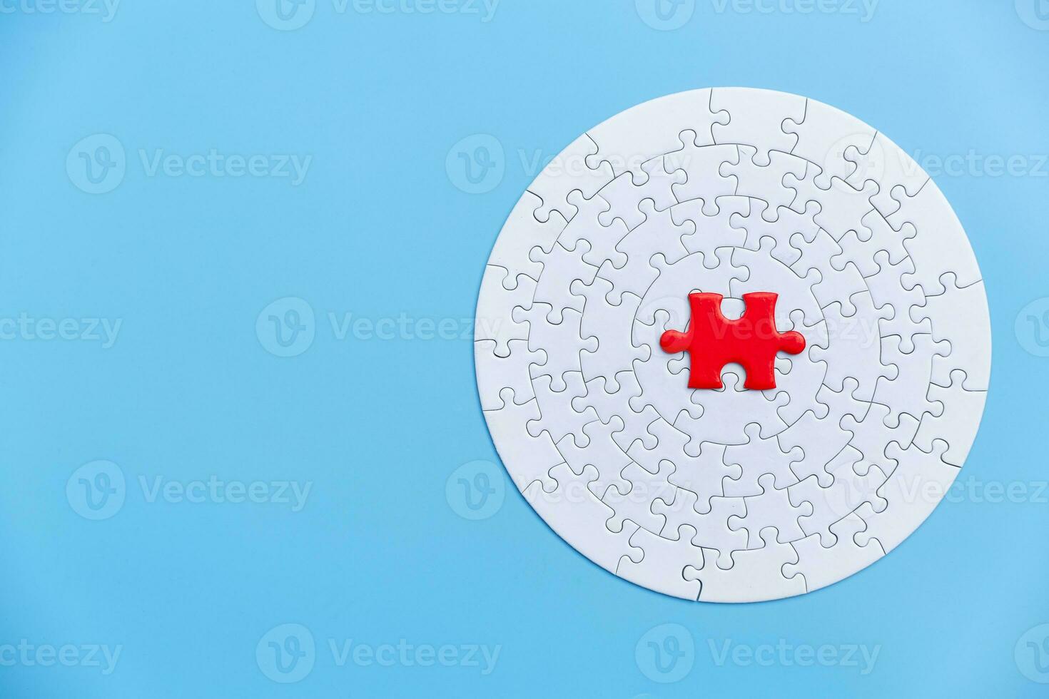 White and red jigsaw puzzle on a blue background. Copy space for text, top view, close up. photo