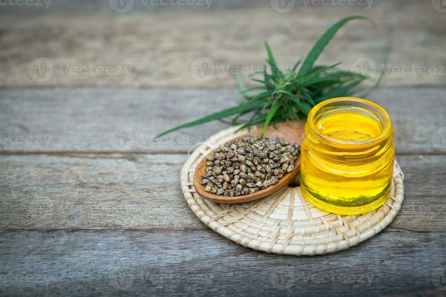 Glass bottles containing  hemp oil and hemp seeds in a wooden spoon,  drugs extracted CBD Cannabis Oil  of researchers or medical team. Herbal alternative medicine. photo