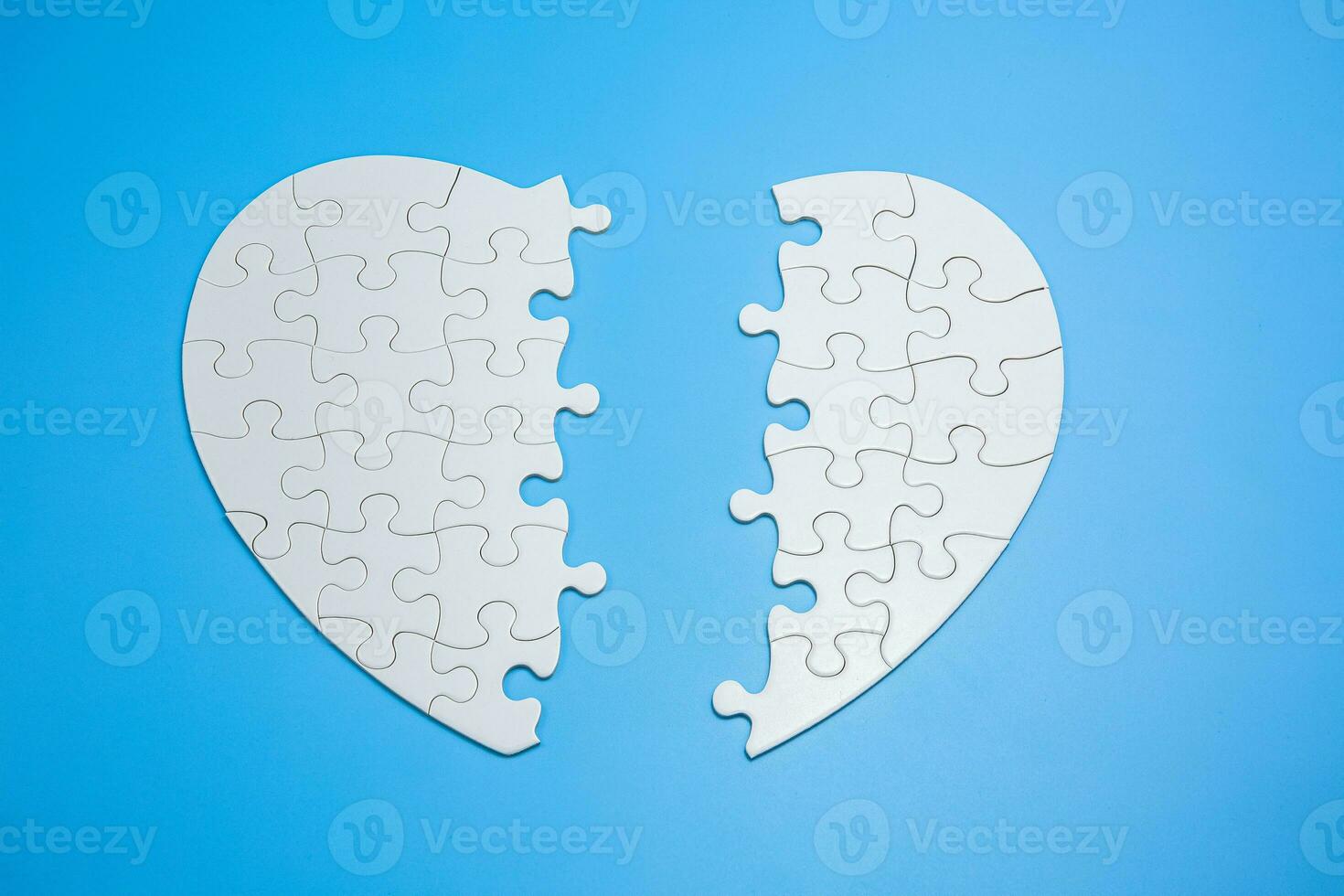 White jigsaw puzzle on a blue background. Completing final task, missing jigsaw puzzle pieces and business concept with a puzzle piece missing. photo