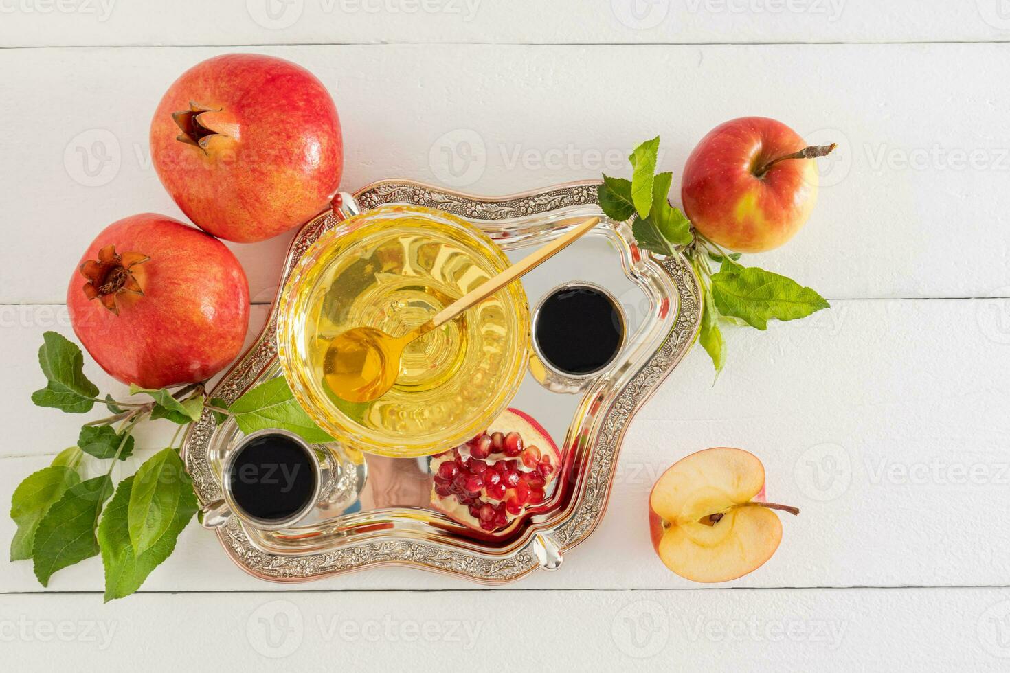 top view of a silver tray with festive products for the Jewish New Year holiday Rosh Hashanah. White wooden background made of boards. photo