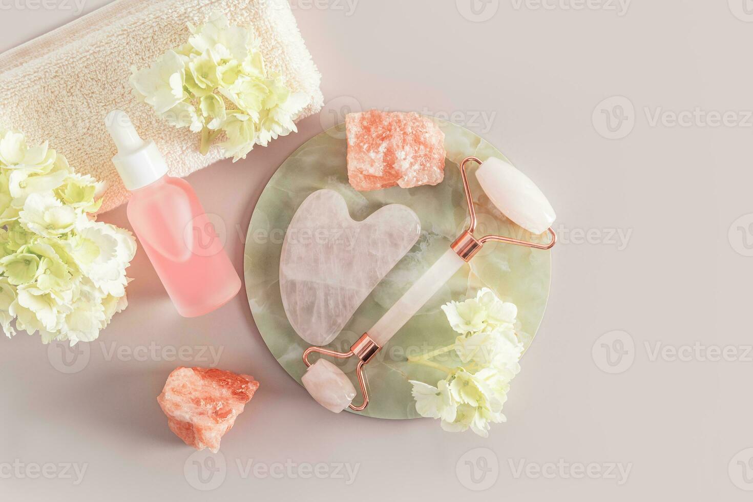 a set of cosmetics and a roller for massage, a gua sha scraper for the care of the skin of the face, neck and decalte area. Top view. pastel. photo
