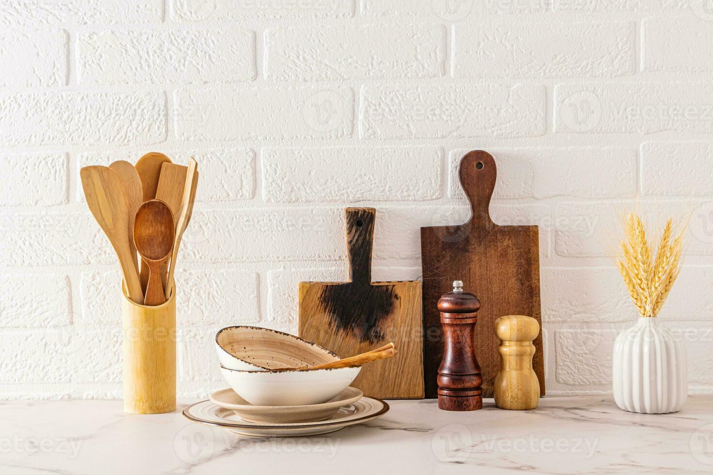 cutting wooden boards, wooden spoons and ceramic utensils on a marble white countertop in a modern kitchen. front view. Eco items. photo