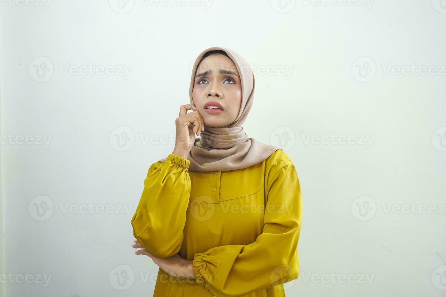 Portrait of thinking young Asian woman looking up and touch chin isolated on over white background photo