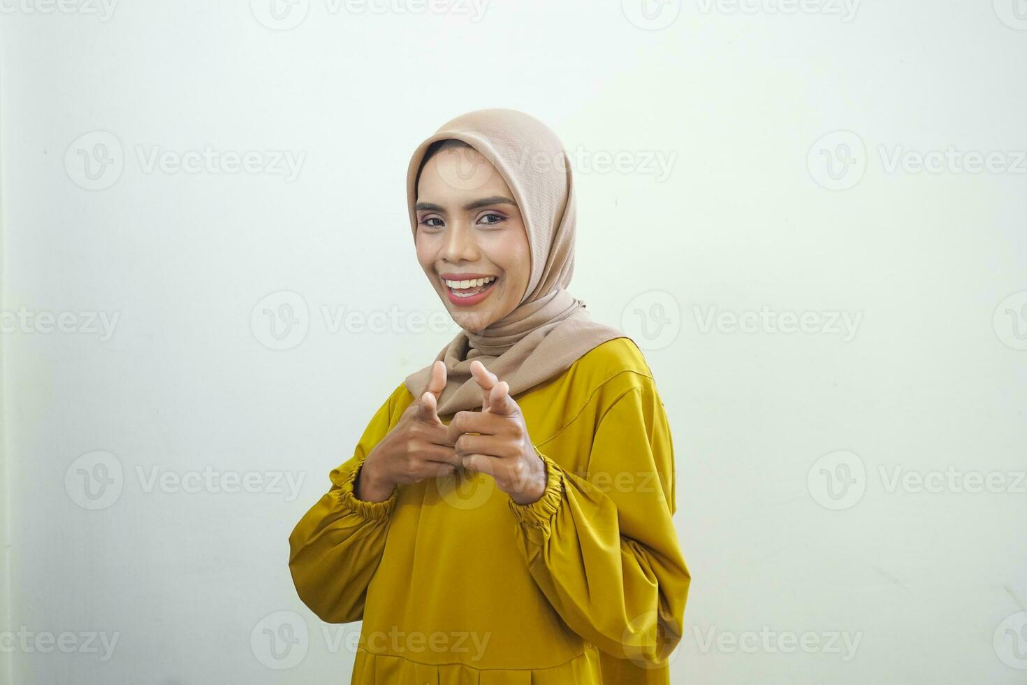 Cheerful beautiful Asian woman in white dress pointing fingers isolated by white background photo