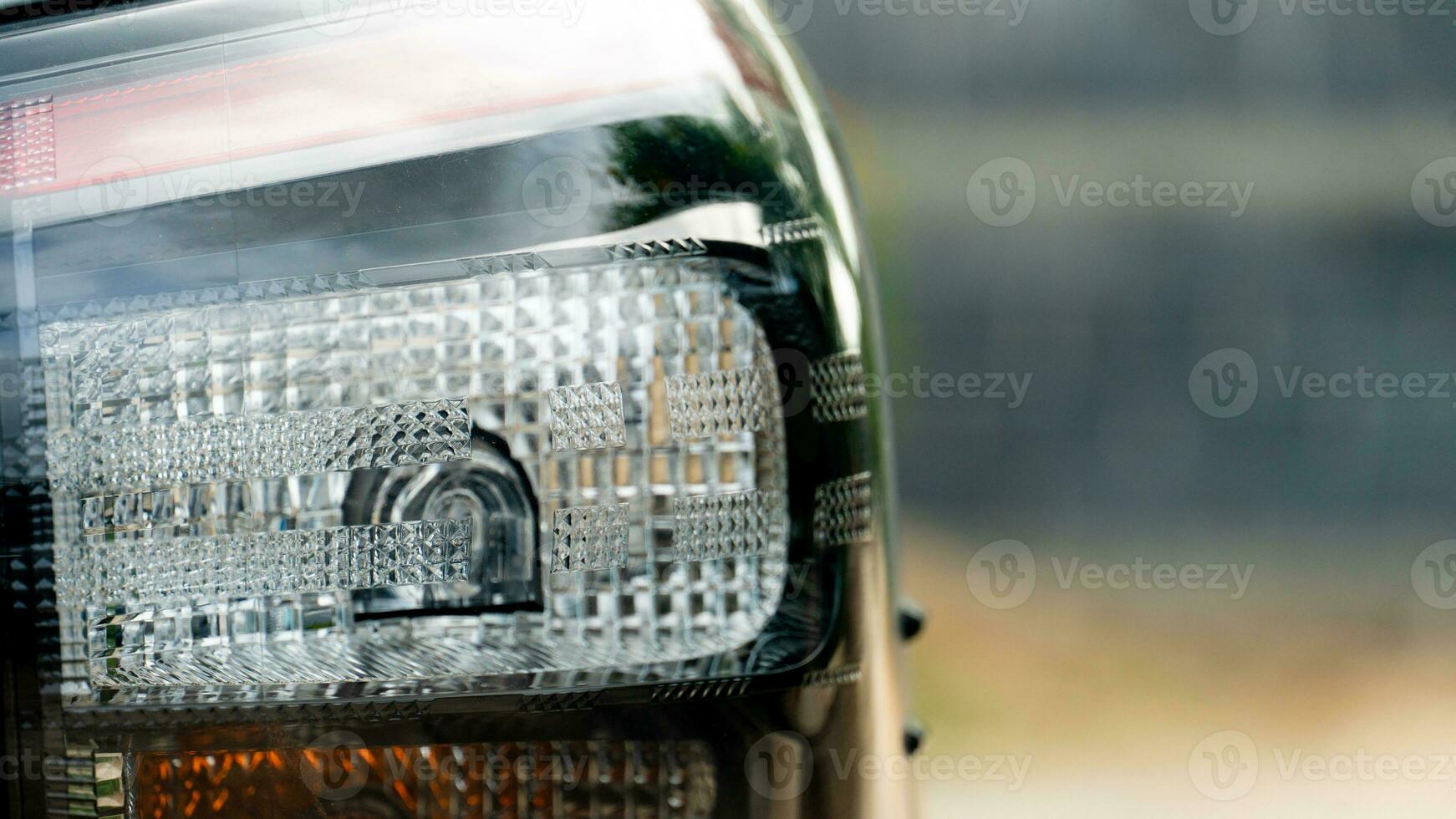 Close up back side of tail light of car. Blurred of wall for background. photo