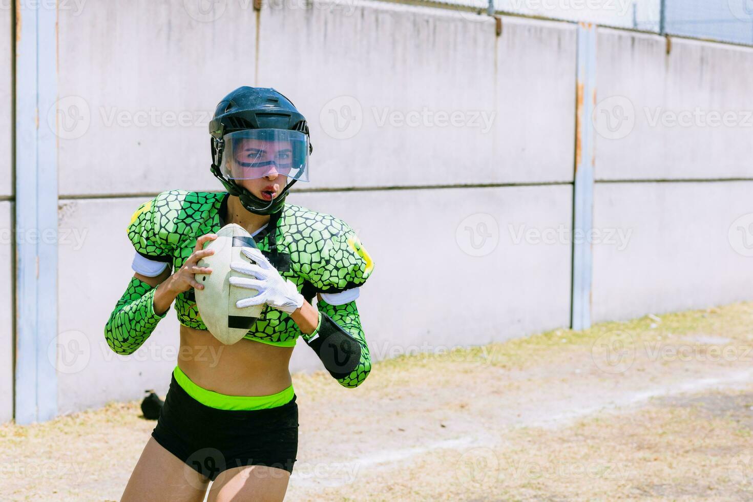 Portrait of mexican woman american football player wearing uniform with velociraptor skin patterns photo