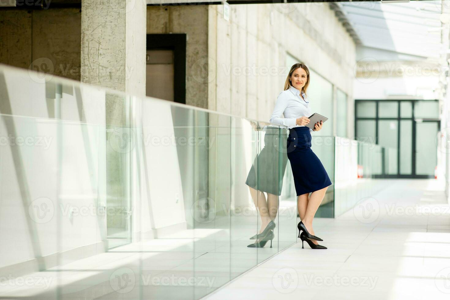 joven mujer trabajando en digital tableta en el oficina pasillo foto
