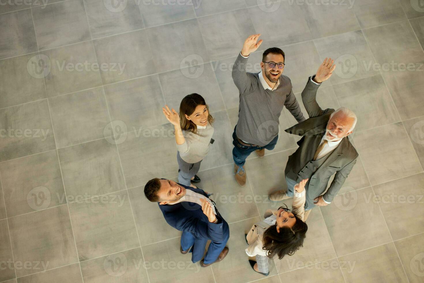 Aerial view at happy business people raise hands together with joy and success in the office hallway photo