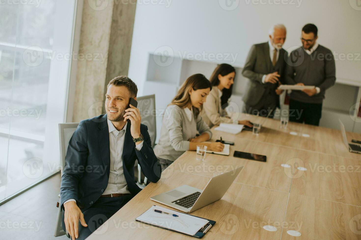 Young business man using mobile phone in the office photo