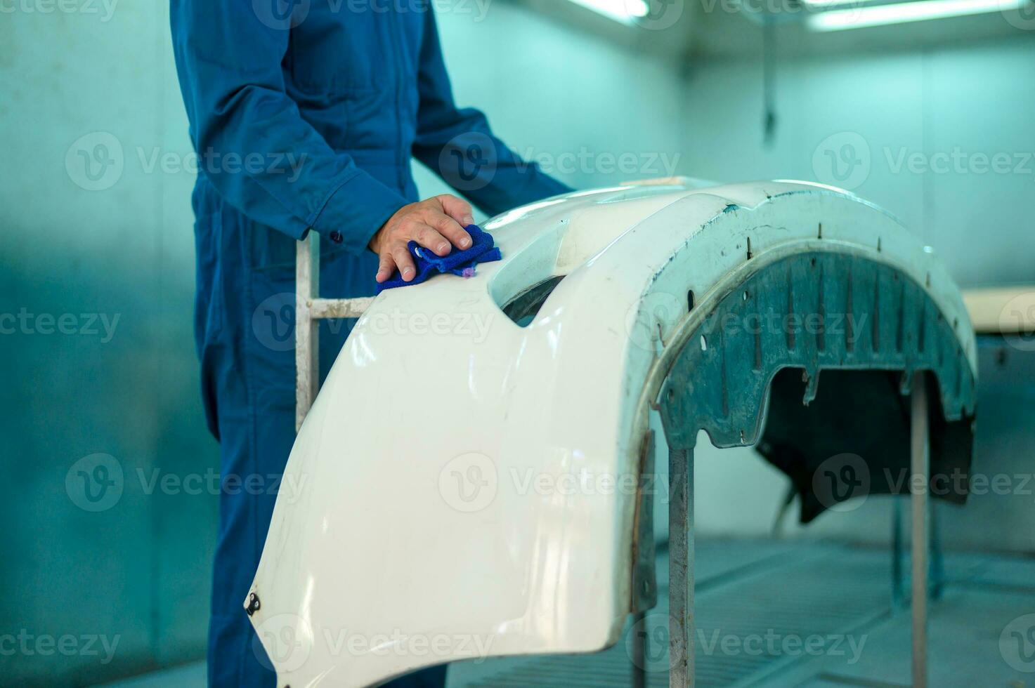 cerca arriba caucásico hombre mano limpieza coche parte antes de pintura en pintar tienda foto