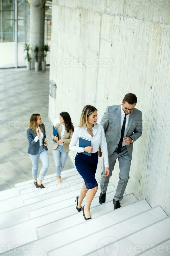 Young startup team have a discussion while climbing on  stairs in the office corridor photo