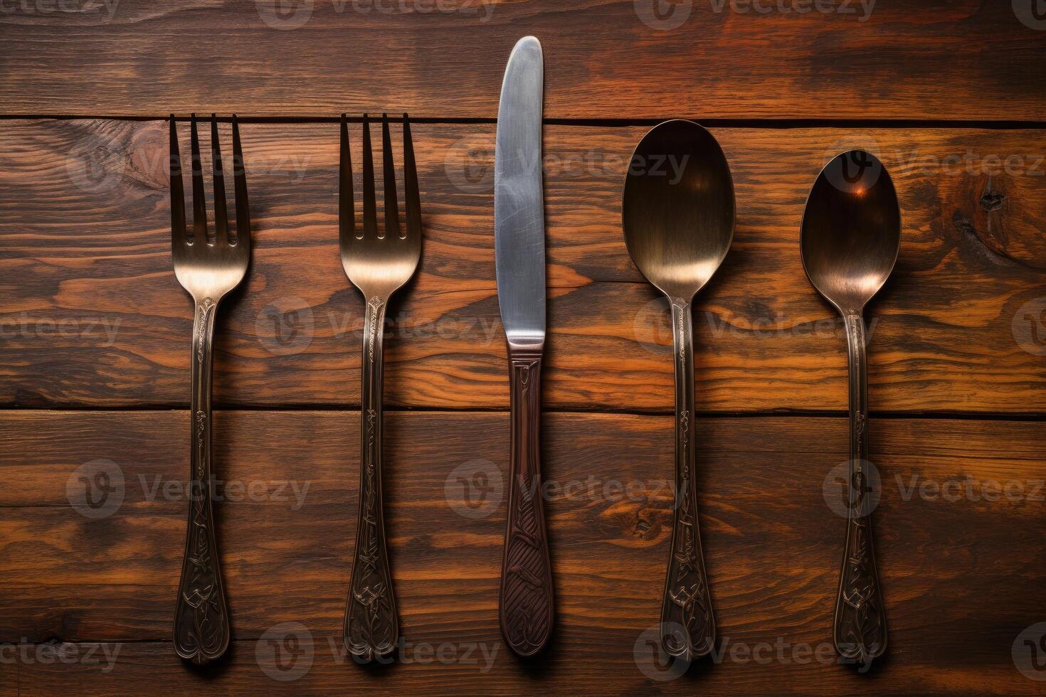 Antique spoon and fork, knife on a wooden table. photo