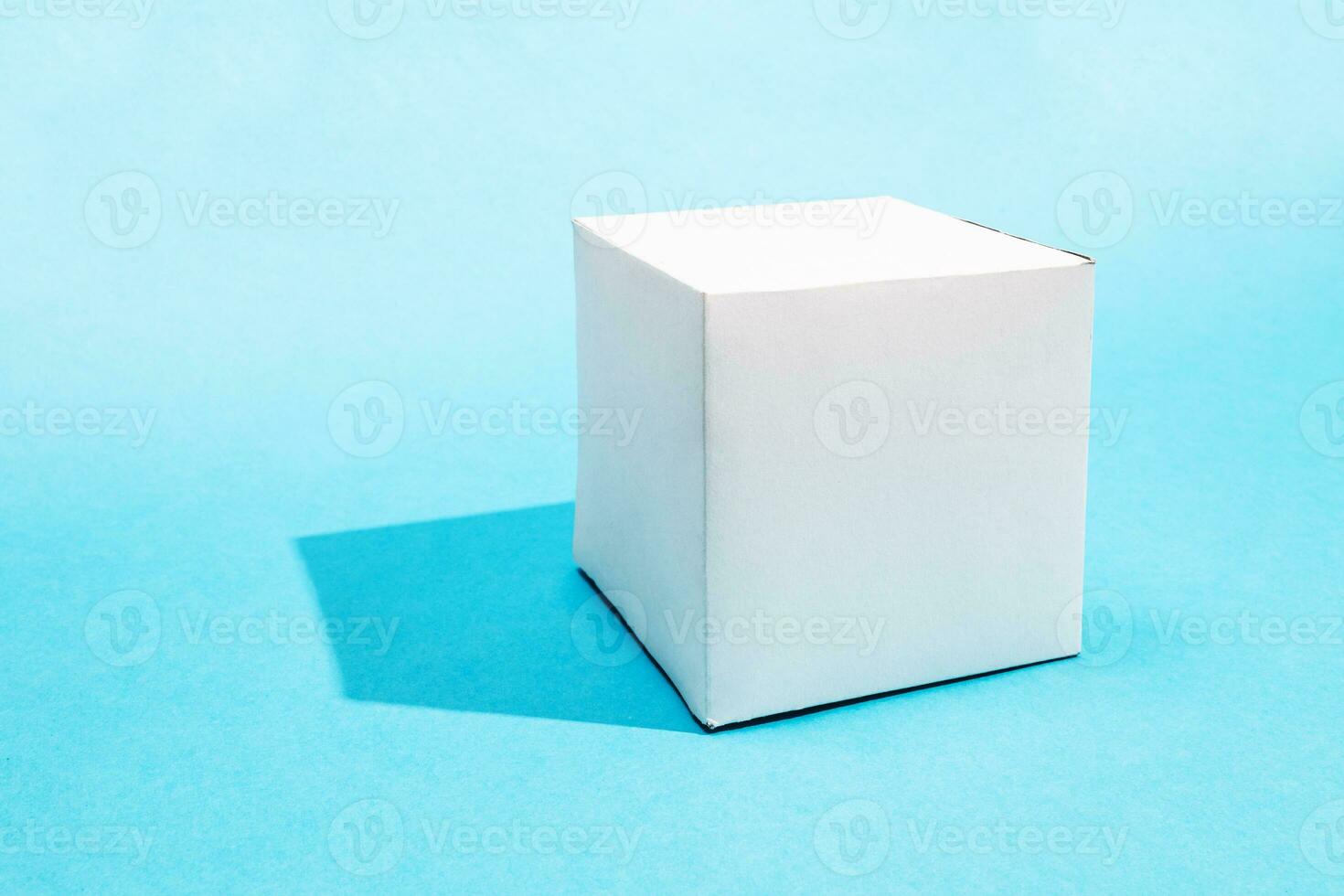 one hand-crafted paper cube on turquoise blue photo