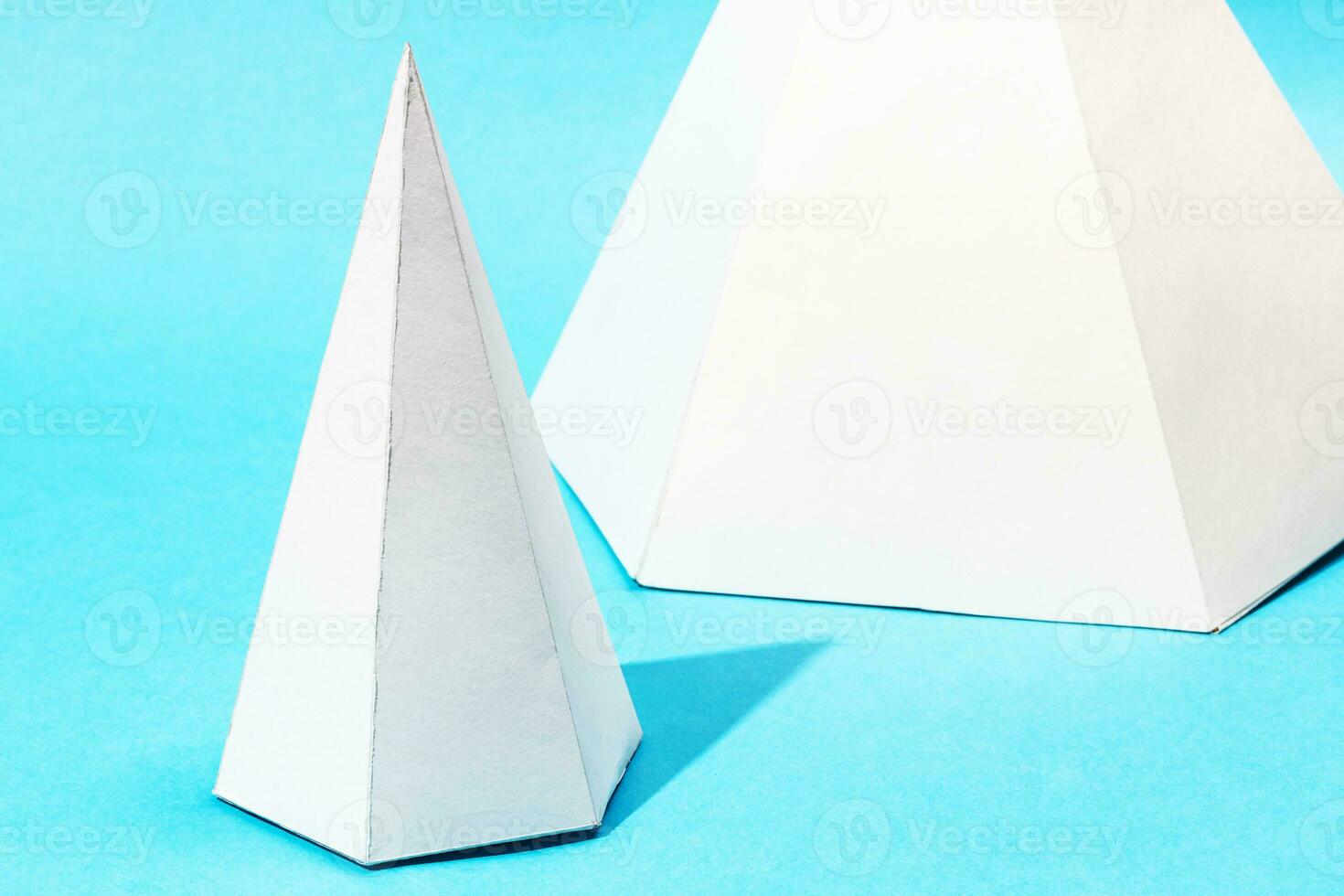 handmade paper pyramids close up on turquoise blue photo