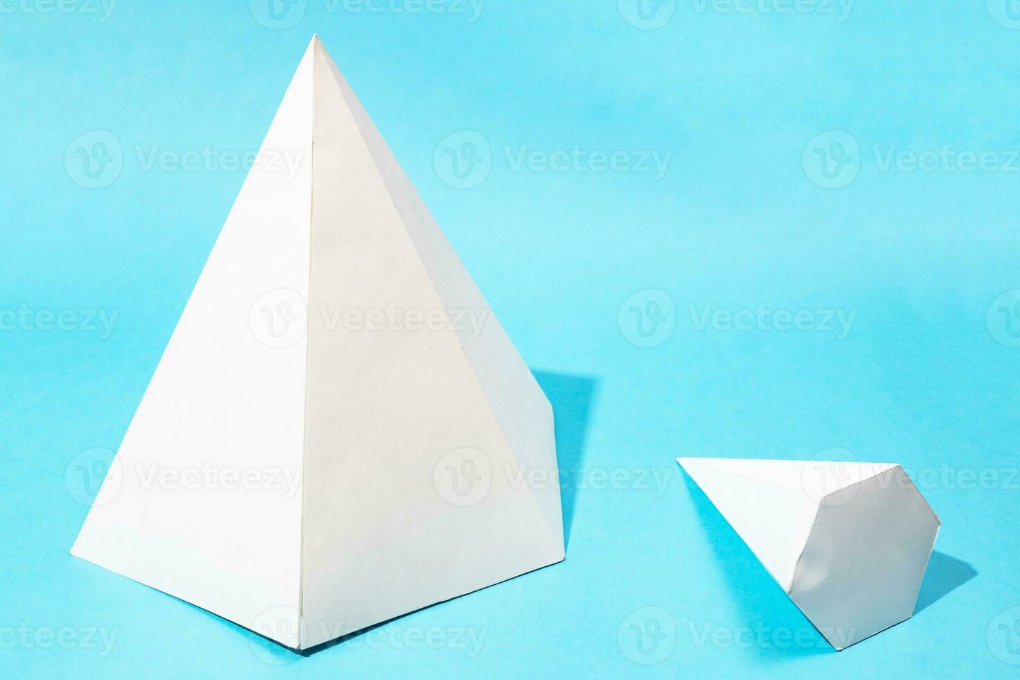 big standing and little lying pyramids on blue photo