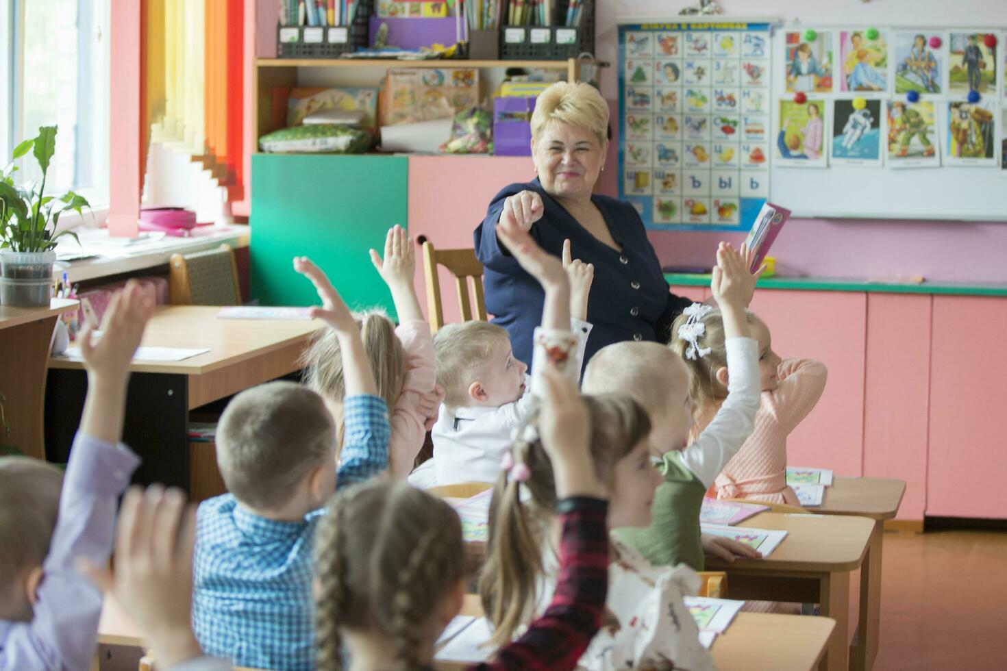 Belarus, the city of Gomil, 26.04.2019 Kindergarten in the city. Primary school teacher and a group of children in the lesson. photo