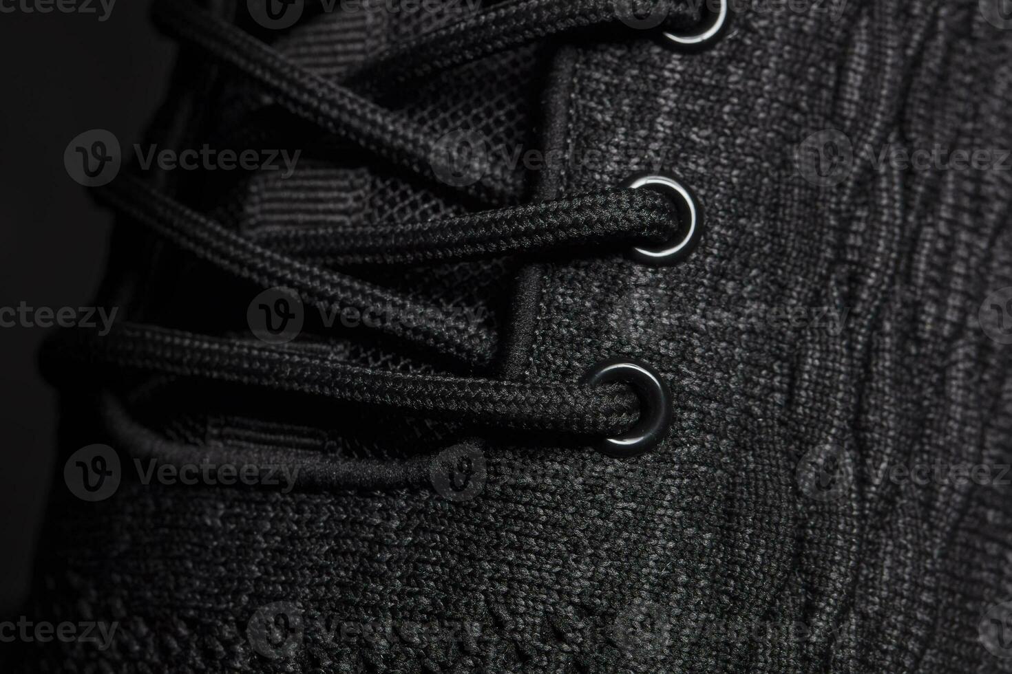 The texture of a black rag sneaker with laces close-up. photo