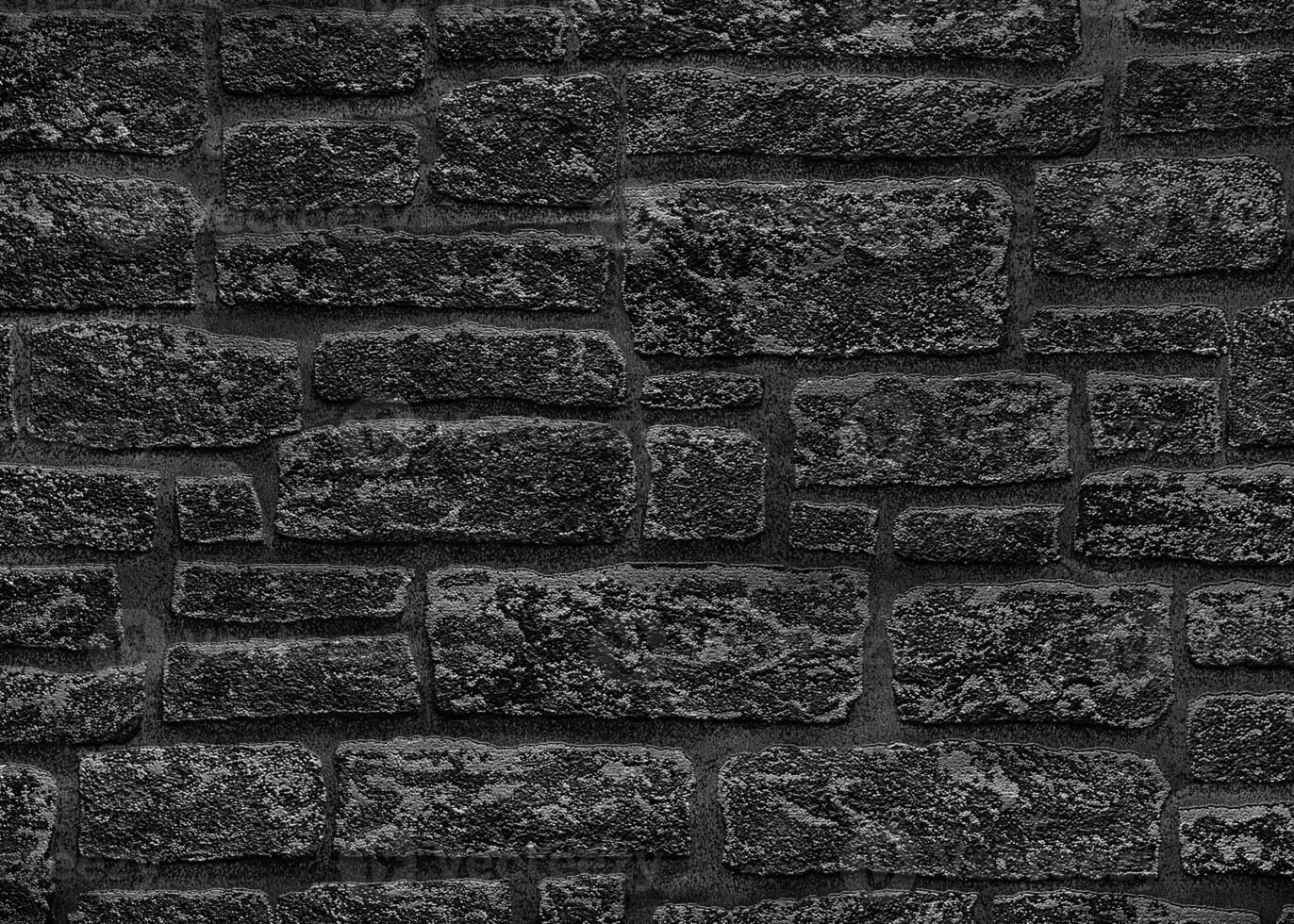 Black brick wall with gray spots. Texture of a rough dark wall. photo