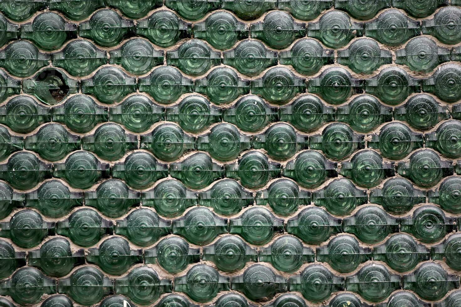 Vintage mosaic from old bottles. Ecological use of old bottles for mosaic on the wall. Texture of glass jars. photo