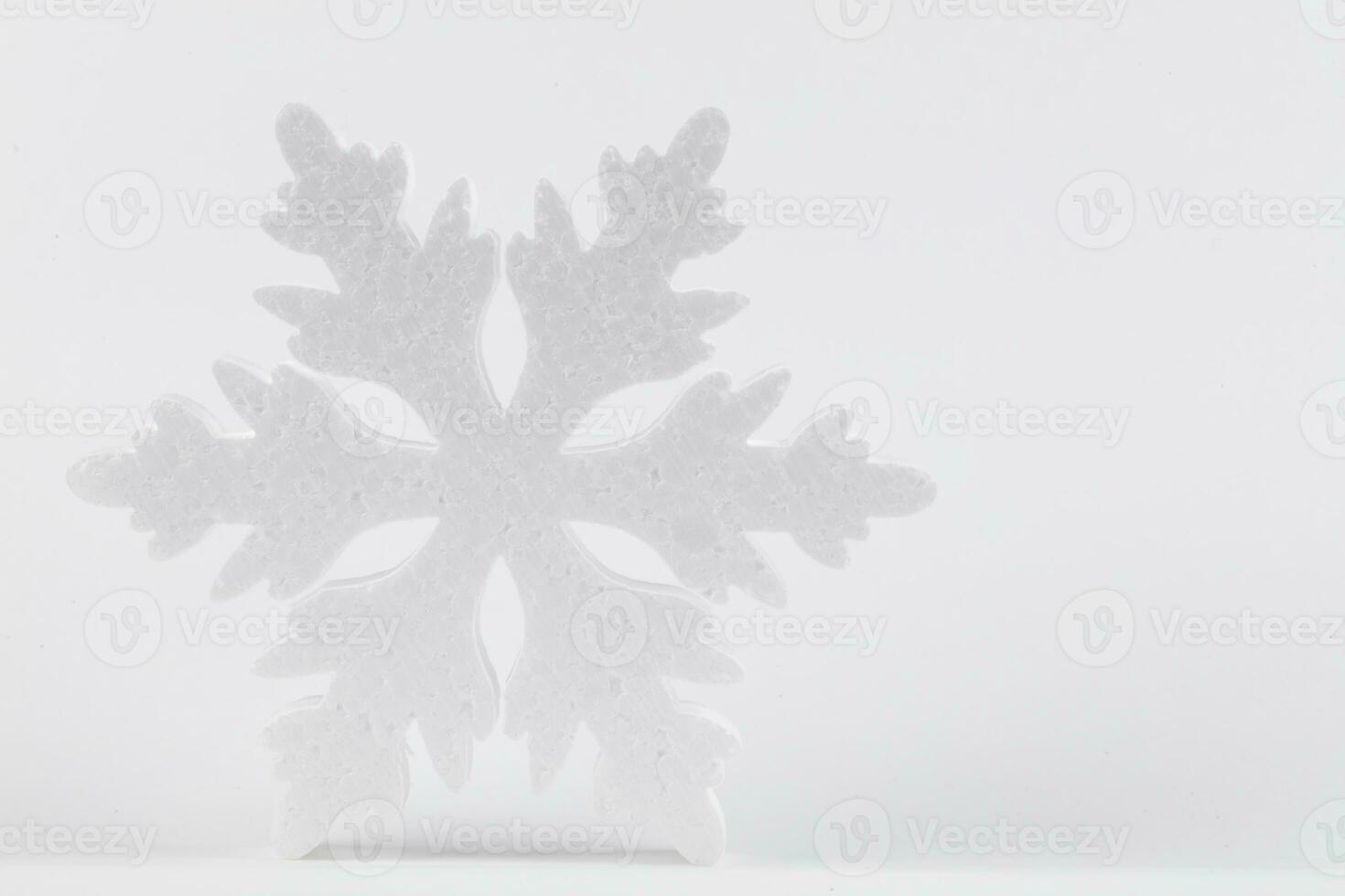 Festive light Christmas background. Large white snowflake on a gray background. photo