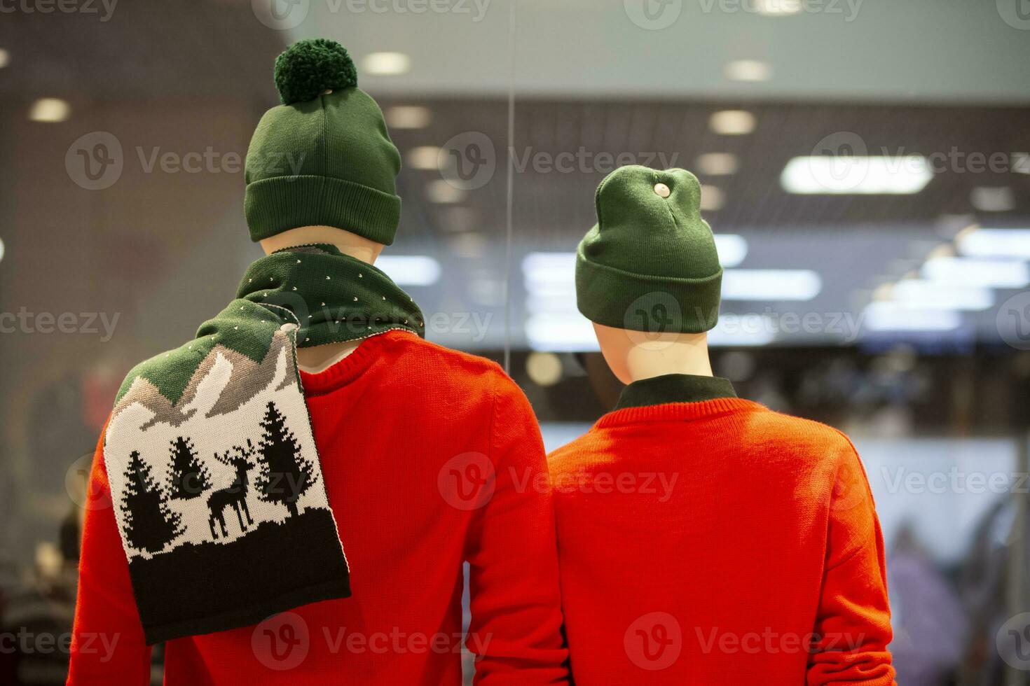 Mannequins of a man in winter red clothes stand with their backs. New year sale concept. photo