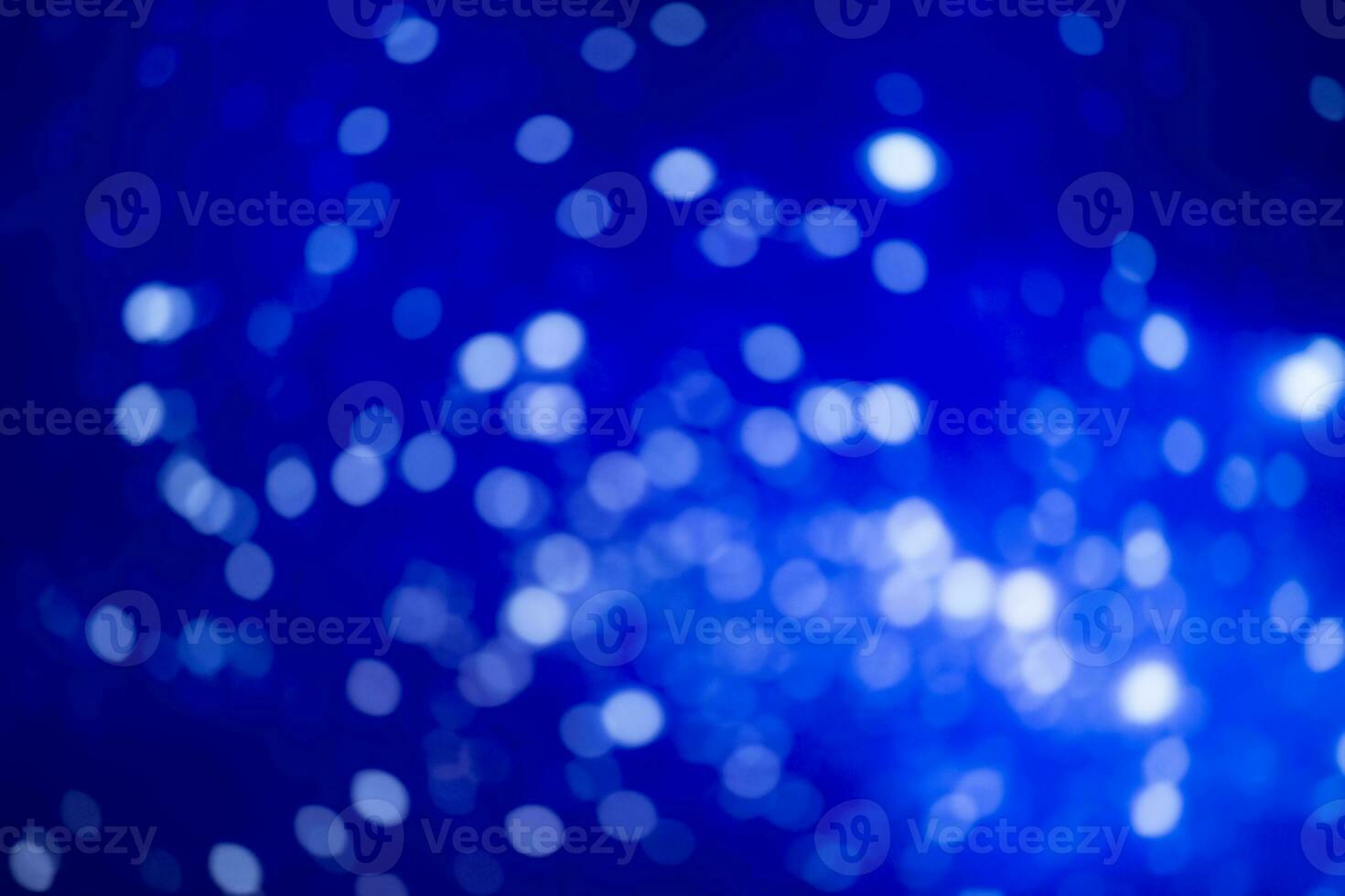 Blue blurred background with white bokeh spots. Festive background. photo