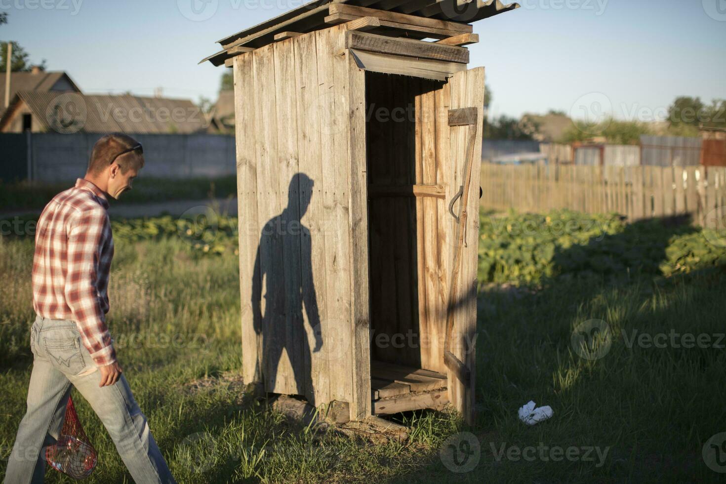 The man goes to the rustic wooden toilet. photo