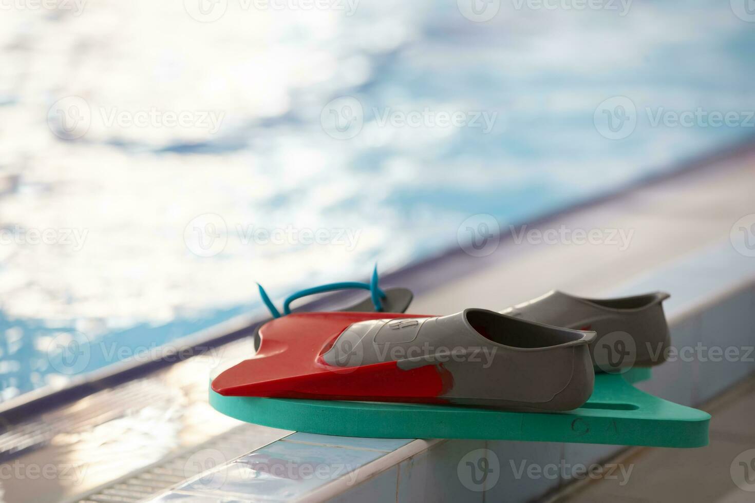 Swimming fins are on the side of the pool. photo
