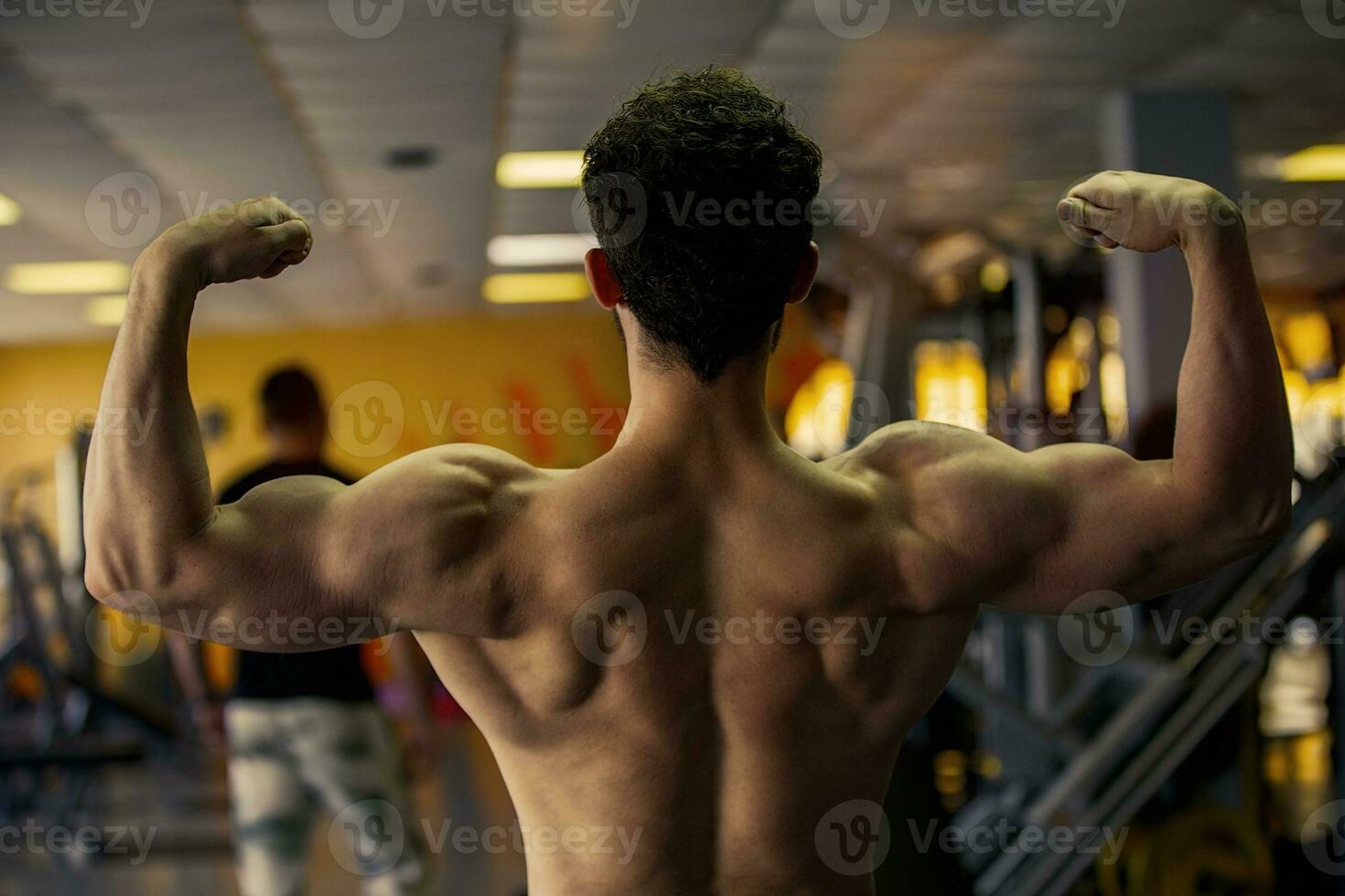 Athletic men show biceps and triceps on their back. photo