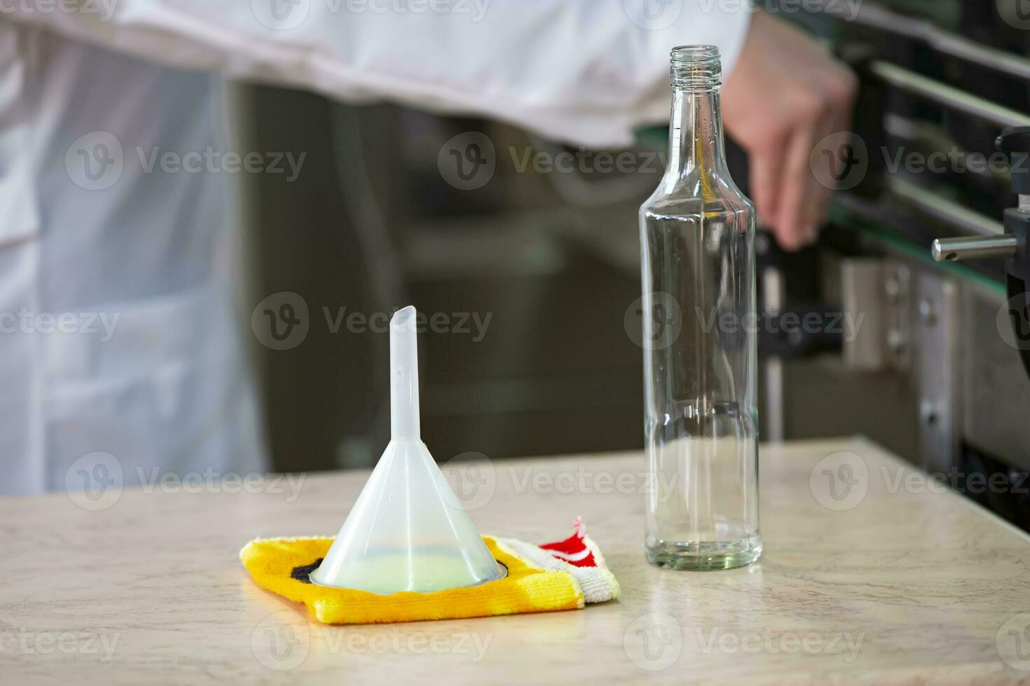 Worker hands and empty bottles on a conveyor belt in the production of alcoholic beverages. photo