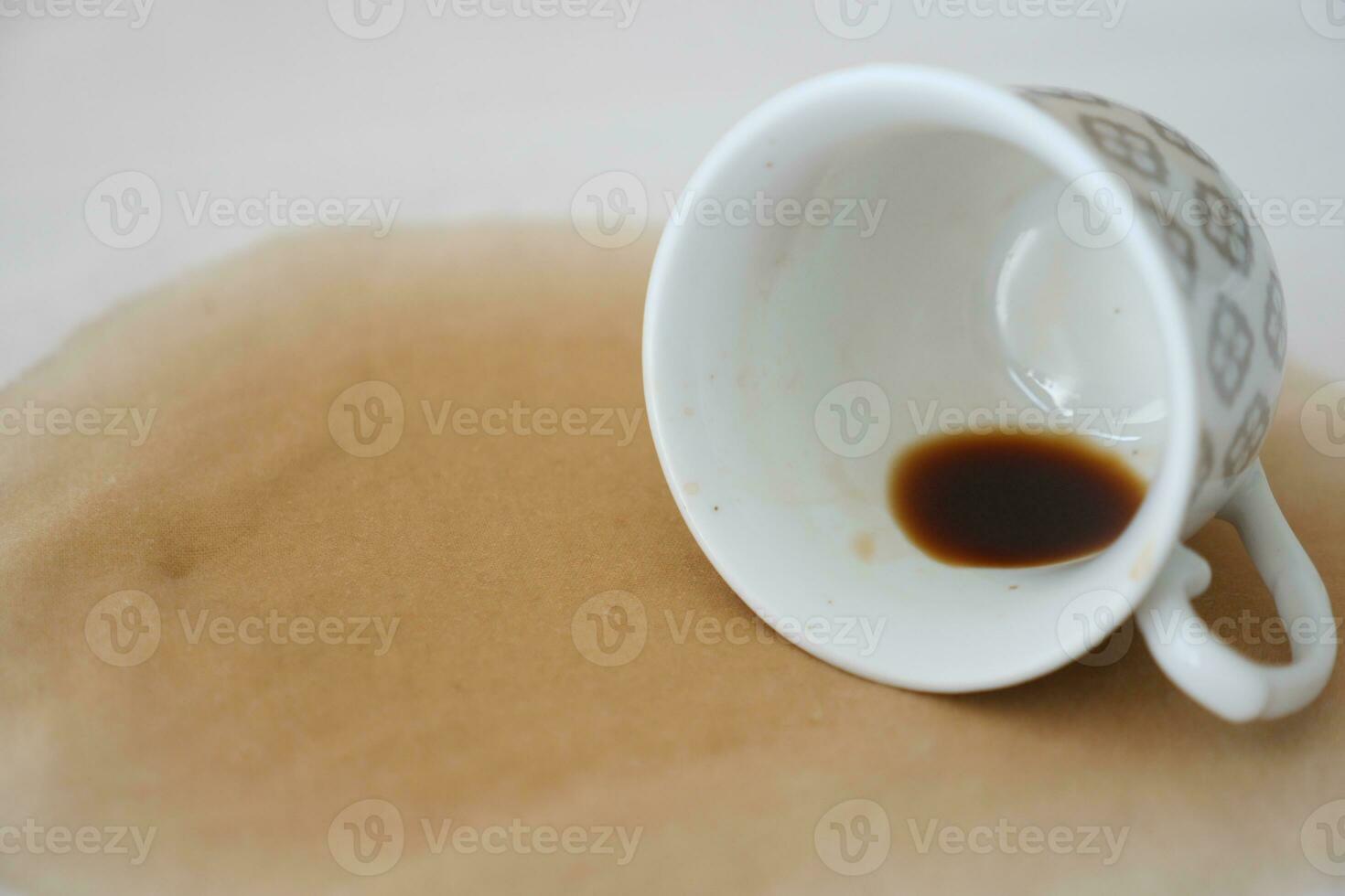 cup of coffee spilled on white bed photo