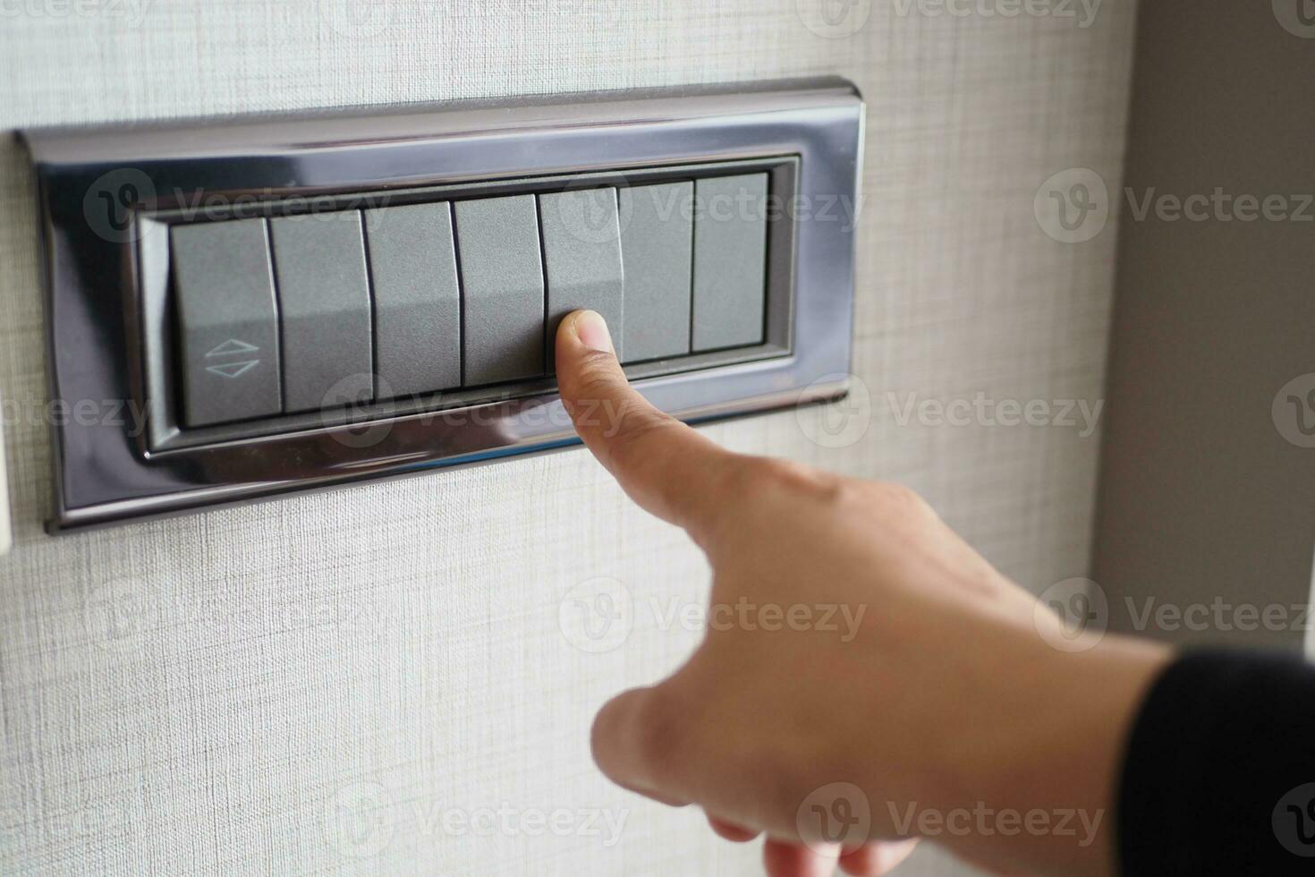 A finger turning on lighting switch . photo