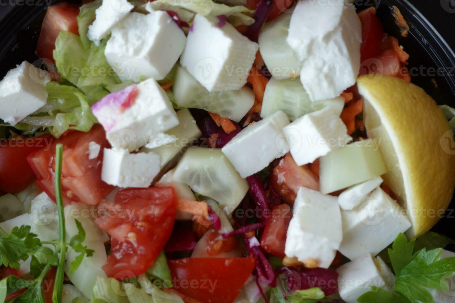 Close up of greek salad in a bowl on table. photo