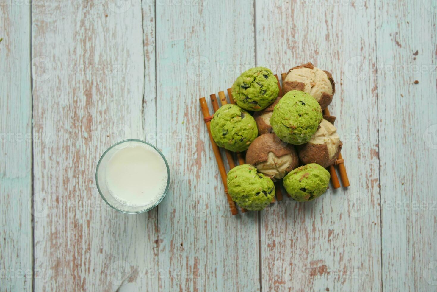 top view of sweet cookies and glass of milk on wooden table photo