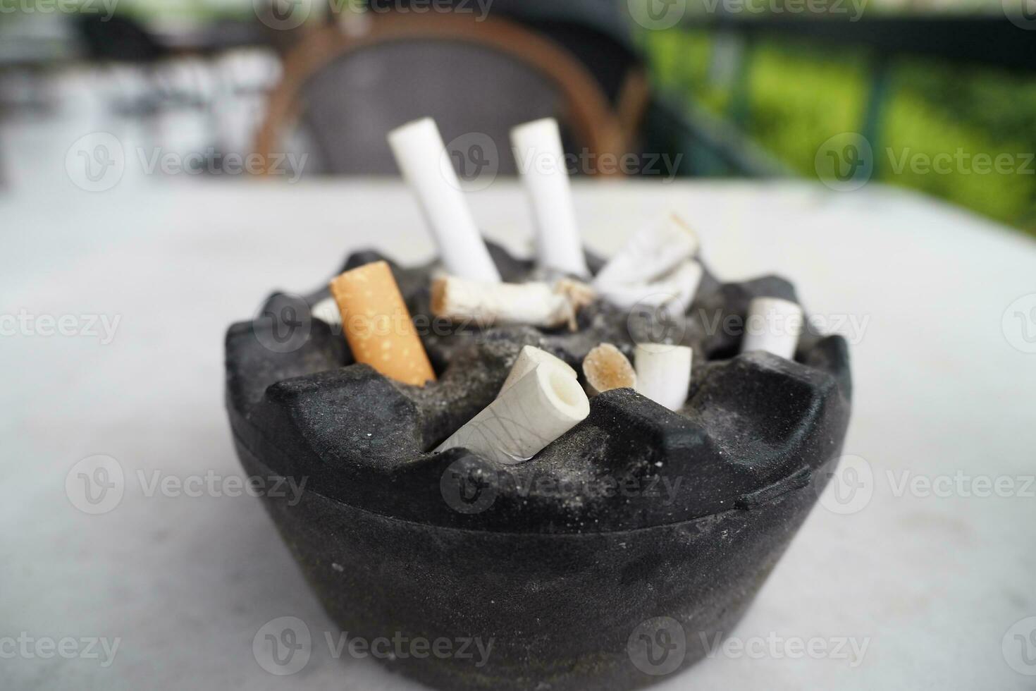 Close up burning cigarette in ashtray on table photo