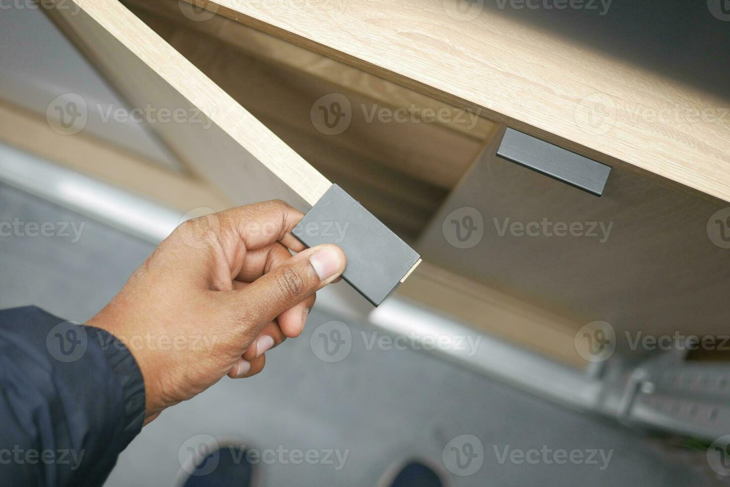 man's hand open drawer wooden in cabinet photo
