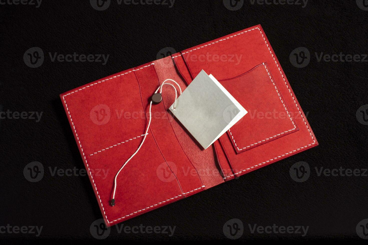 Open leather red purse with pockets on a dark background. photo