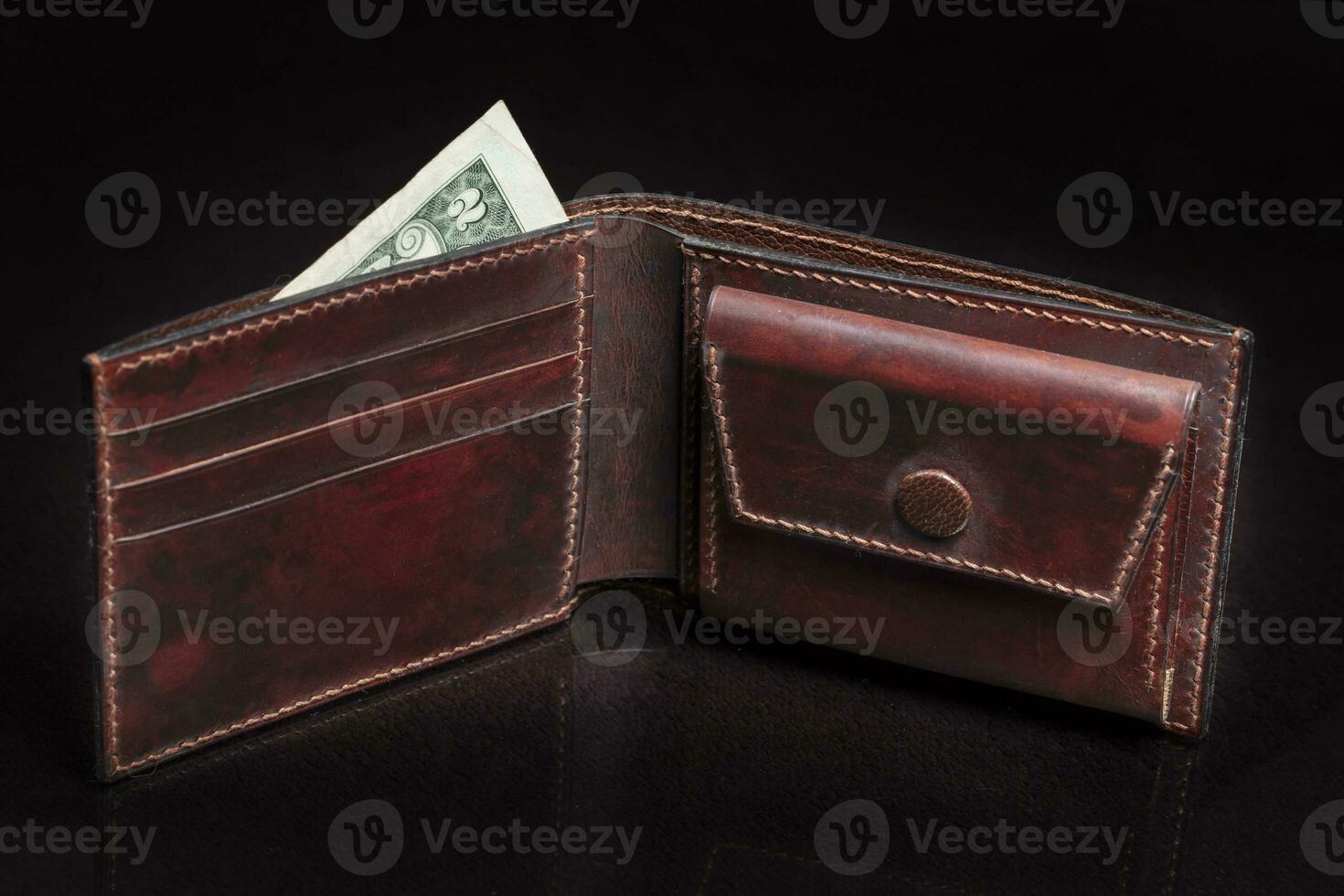 Open leather brown purse with pockets on a dark background. photo