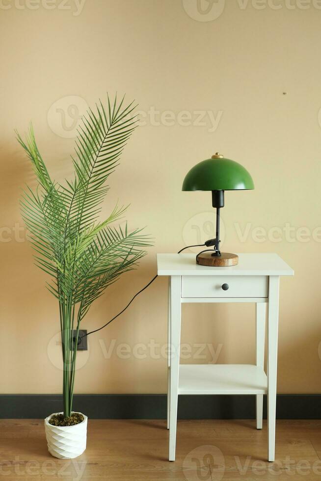 a lamp on wooden table and a decorative plant at home photo